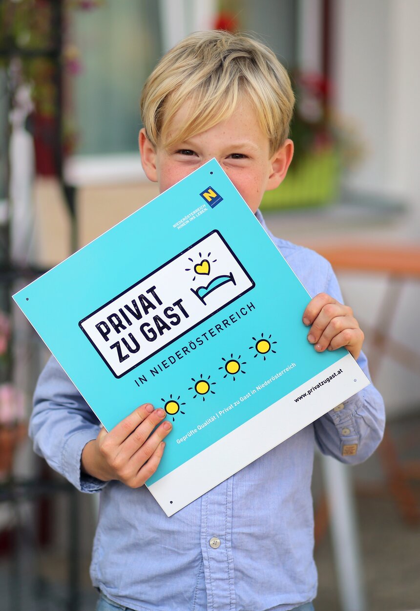 Bub hält Privat zu Gast Tafel in der Hand | © Privat zu Gast in Niederösterreich / weinfranz.at