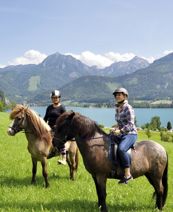 Zwei Freundinnen reiten mit Blick auf den Wolfgangsee, Salzkammergut | © Urlaub am Bauernhof Oberösterreich / Harald Puchegger