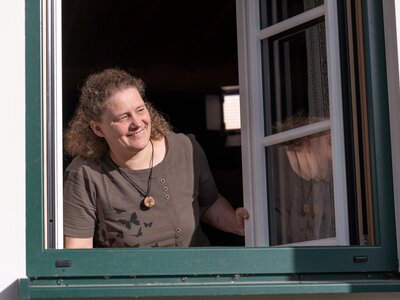 Herzlich willkommen bei Urlaub am Bauernhof! | © Oberösterreich Tourismus GmbH / Martin Fickert Bäuerin schaut beim Fenster heraus | © Oberösterreich Tourismus GmbH / Martin Fickert