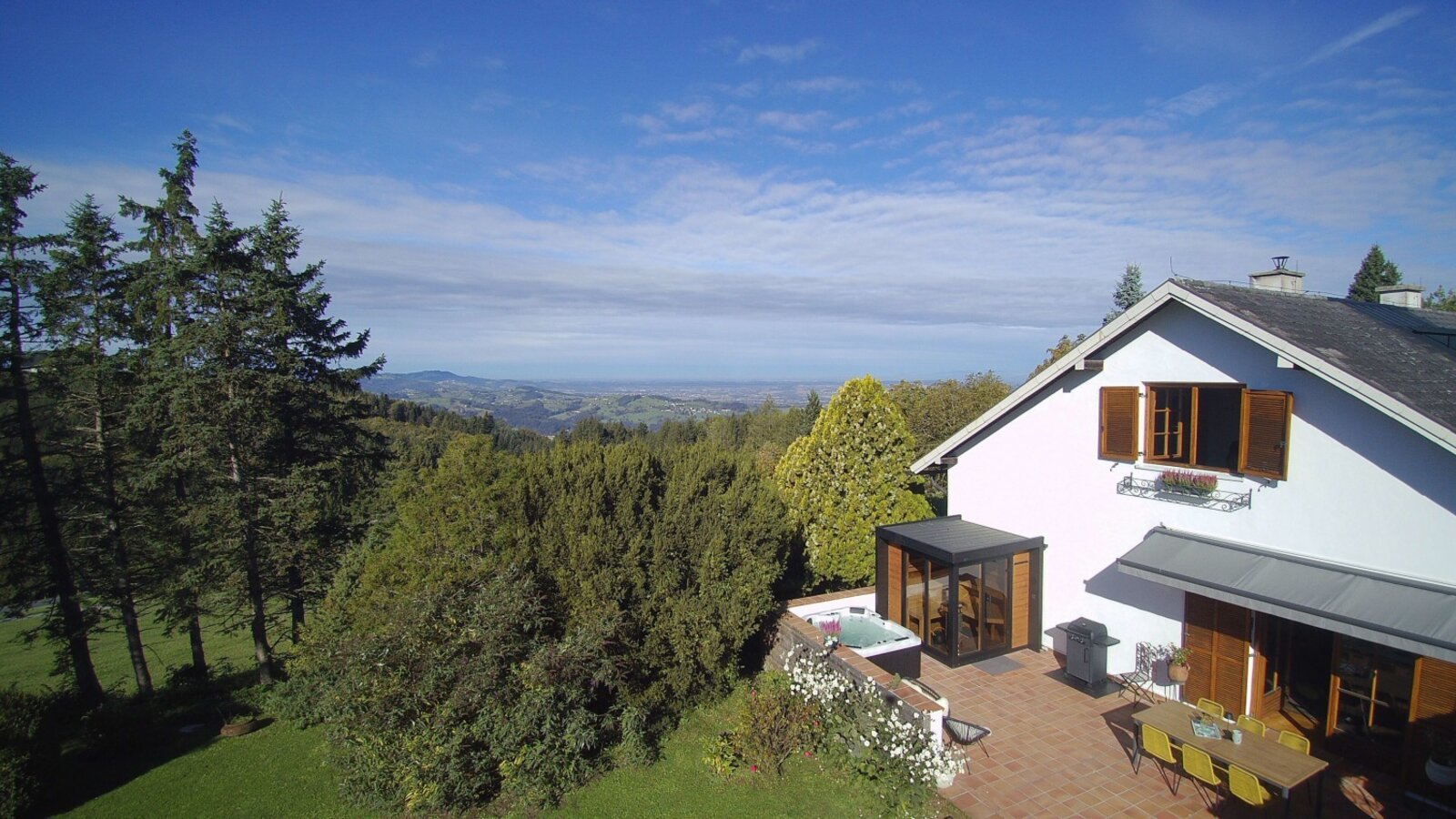 Außenansicht mit Terrasse, Essbereich im Freien, Whirlpool und Blick auf die umliegende Landschaft.