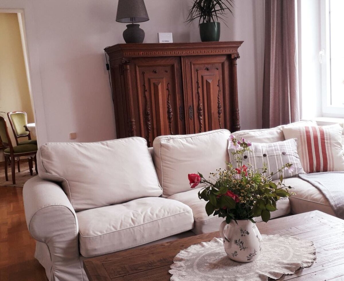 Wohnbereich in der Unterkunft mit hellem Sofa, Couchtisch und Zugang zum Esszimmer.