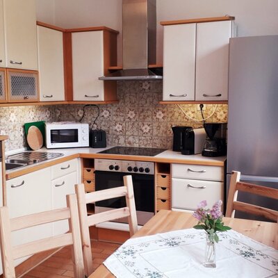 Die Küche der Unterkunft bietet einen Esstisch und ist mit Spülmaschine, Herd, Backofen, Mikrowelle, Kühlschrank und Kaffeemaschine ausgestattet.