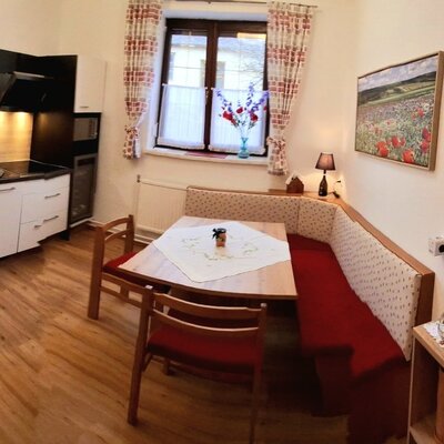 Moderne Küche im Bauernhof mit Backofen, Spülbecken und Kochfeld sowie einem Essbereich mit Eckbank.