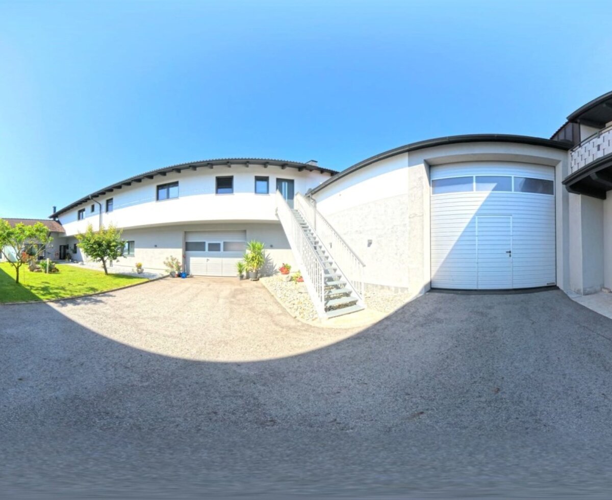 Der weitläufige Innenhof des Hauses mit gepflegten Grünflächen und einem sonnigen Außenbereich.