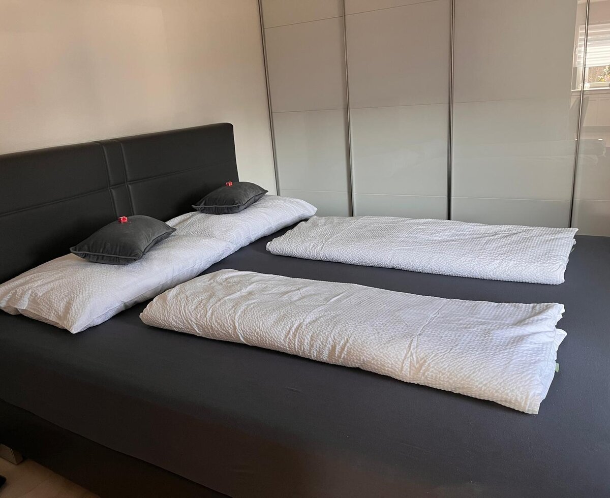Schlafzimmer mit Doppelbett und großem Kleiderschrank.