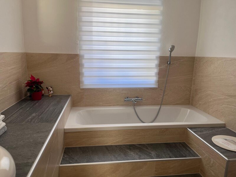 Badezimmer mit Badewanne und Duschvorrichtung.