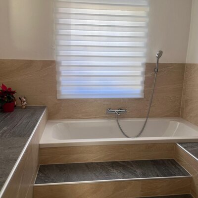 Badezimmer mit Badewanne und Duschvorrichtung.