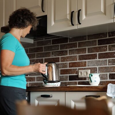 Die Küche des Appartements auf dem Bauernhof ist mit einer Kaffeemaschine, einem Wasserkocher, einer Spüle und einer Holzarbeitsplatte ausgestattet.