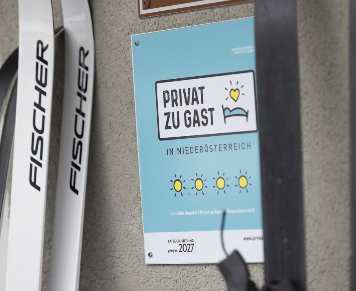 Die "Privat zu Gast" 4-Sonnen-Klassifizierung des Bauernhofs in Niederösterreich ist bis 2027 gültig, mit Skiern, die auf Freizeitmöglichkeiten hinweisen.