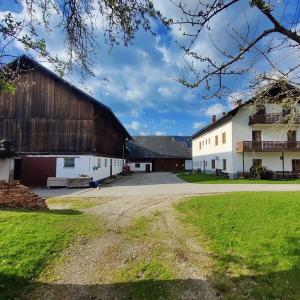 Außenansicht des Bauernhofs mit Stall und Wohngebäude.
